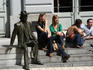 Students relaxing on steps by statue in the University Quarter.
