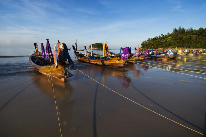 Wooden boats moored on shore of Karon Beach.