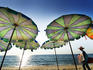 Ice-cream seller walking by beach umbrellas, Surin Beach.