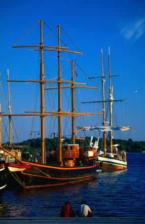 Old sailing ships on the harbour beneath a blue sky