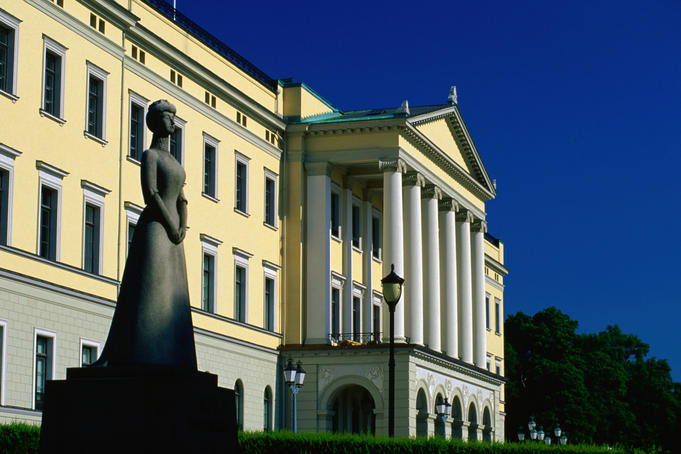 A stone sculpture in front of the Royal Palace