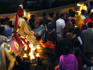 Bridegroom and his wedding procession moving through street.