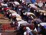 Men praying on steps of Jama Masjid during Friday midday prayers.