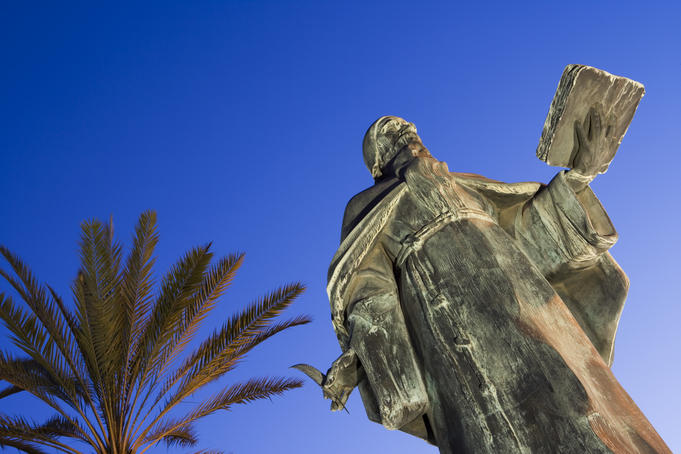 Statue of philosopher Ramon Llull in twilight.