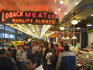 Crowded Pikes Place seafood market interior.
