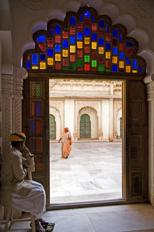 Palace guard and cleaner framed in doorway at Mehrangarh Fort.