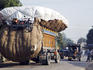 Transporting motorbike and stockfeed on truck.