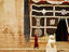 Smiling monk walking towards entrance to Ganden Sumtseling Gompa (Songzanlin Si) monastery.