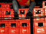 Coke dude: a man sitting on crates of Coca-Cola