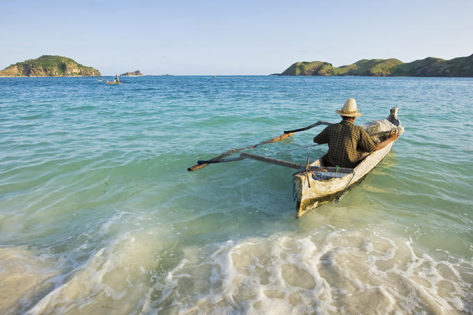 Fisherman paddling his boat out from Kuta Beach.