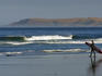 Surfer walking on Morro Strand State Beach.