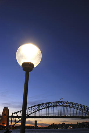 Street light and Sydney Harbour Bridge at evening.