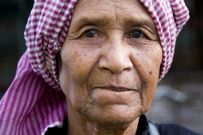 Portrait of flower seller at Psar Nat market wearing a Krama (traditional checkered scarf worn by Khmers).
