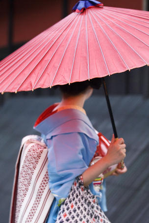 Geisha with umbrella in Gion district.