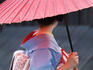 Geisha with umbrella in Gion district.