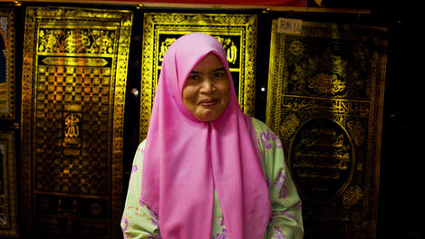 Portrait of female carpet seller at night market.