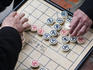 Elderly men playing Chinese Chess (Xiang Qi) outdoors at Ngoc Son Temple (Jade Mountain Temple).
