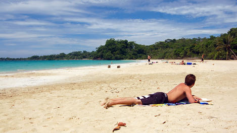Man sunbathing on beach.