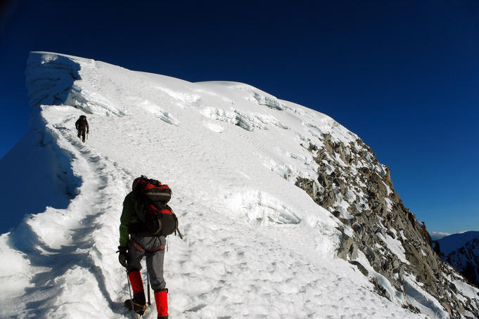 Hiker and his guide ascending to the peak of Nevado Vallunaraju, Cordillera Blanca region.