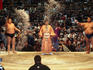 Famous wrestler Kinoshiki (right) and fellow sumo wrestler throwing salt to purify ring before their bout begins.