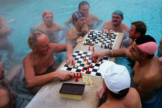 Men playing chess in the warm waters of the Szechenyi Baths.