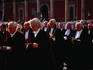 Men in black robes taking part in the Corpus Christi Procession.