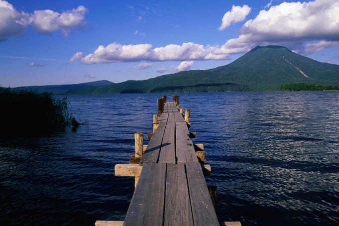 A wooden jetty stretches out onto Lake Akan, pointing towards Mt O-Akan - Hokkaido