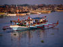 A brightly coloured fishing boat passes the squatting area on Manila Bay.