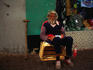 A homeless man sitting on a wooden box in the street