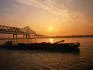 A barge on the Mississippi, silhouetted against the setting sun