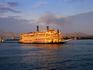 The Mississippi Queen, a steamboat on the Mississippi, bathed in golden light from the setting sun