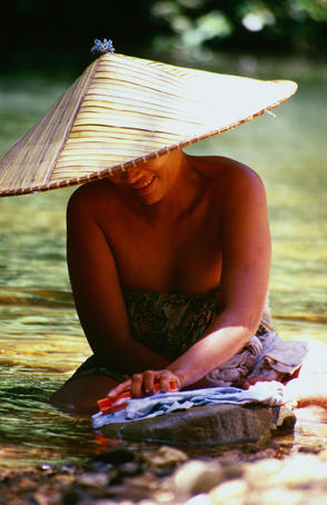 An Iban woman does her washing in the Kesit River, the Iban people, at 500,000 are the largest single ethnic group in Sarawak