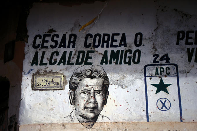 A political mural with bullet holes