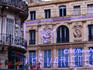 Flags, neon signs, wrought iron balconies and carved decorative features on buildings along the Canabiere, a major thoroughfare