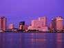 The pink and purple glow of the sunset over the Mississippi River and city skyline