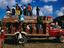 People standing on roof of crowded intercity bus.