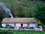 A farm house with smoke blowing from the chimney, Glengesh Valley, Ardara, County Donegal