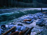 A lone visitor to the Olympic National Park stands on the rocky banks of the North Fork of the swiftly flowing Quinal River