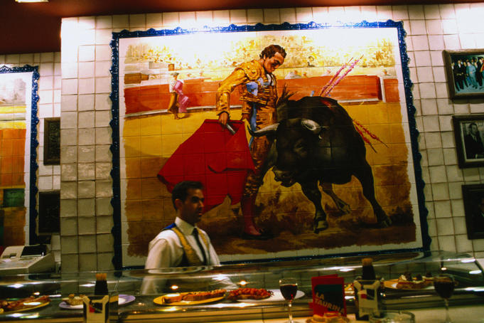 A large picture of a bull-fight painted onto tiles behind the bar of La Torre del Oro in Madrid.