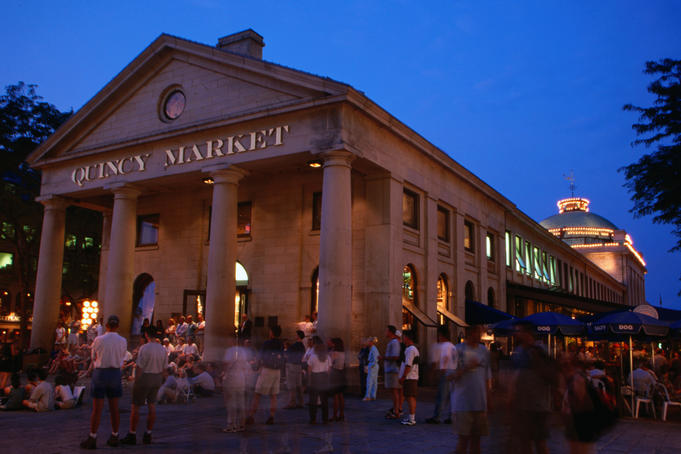 Crowds of people outside the Quincy Market building at night