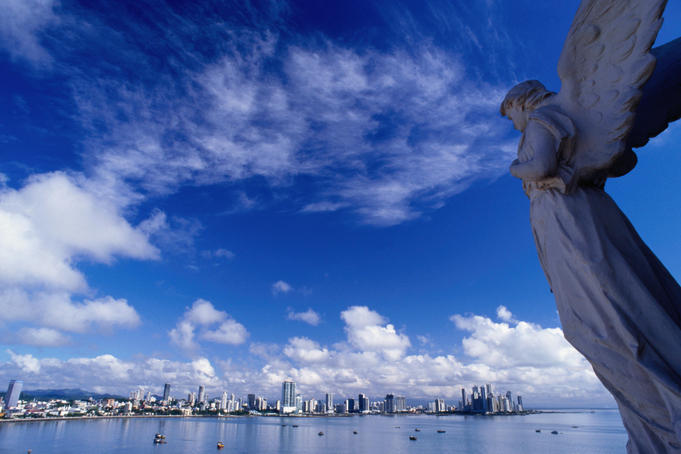 Statue of an angel and city skyline.