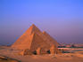 Pyramids Mycerinus, Chephren and Cheops at Giza with Cairo suburbs in background.