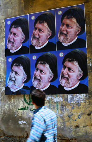 Passerby looking at political posters on wall.