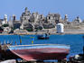 Boat with ruined coral port of Suakin in distance.
