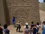 A guide explains the carvings on the Temple of the Dragon to tourists at the ancient site of Trujillo.