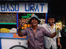 Local characters playing up to camera in front of food stall.