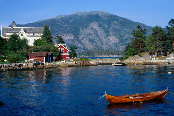 A wooden canoe floats on the Sognefjord in the scenic Western Fjords region.