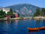 A wooden canoe floats on the Sognefjord in the scenic Western Fjords region.