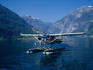A seaplane lands on the blue waters of Geirangerfjord. One of the best way to see the spectacular scenery of the Western Fjords is by air.
