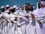 Men performing traditional dance with sticks.